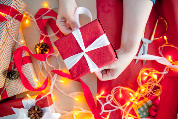 istock Female hands wrapping red christmas gift boxes 1088165506