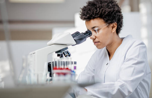 young scientist working with the microscope - hematology imagens e fotografias de stock