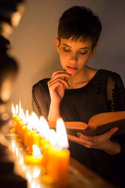 istock Woman reading the book under candlelight 1088179656