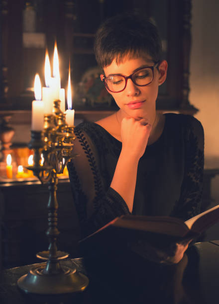 istock Woman reading the book under the candlelight 1088179674