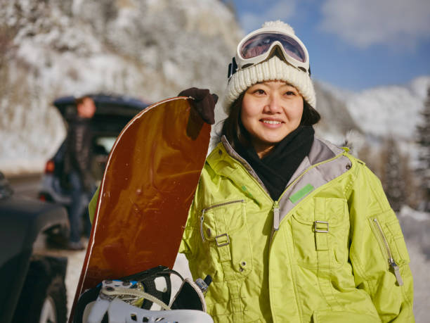Young Adults Enjoying a Winter Outing Young adults enjoying a winter outing, driving their vehicles in the mountains. japanese snowboarder stock pictures, royalty-free photos & images