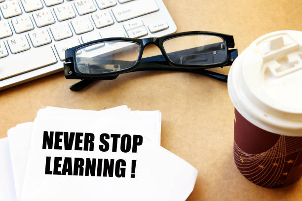 istock never stop learning ! on white paper with coffee and eyeglasses, white keyboard 1088189072
