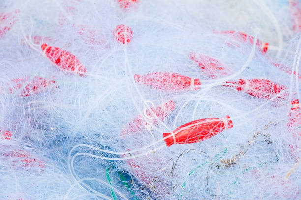 Fishing nets in pile mixed with round red floaters
