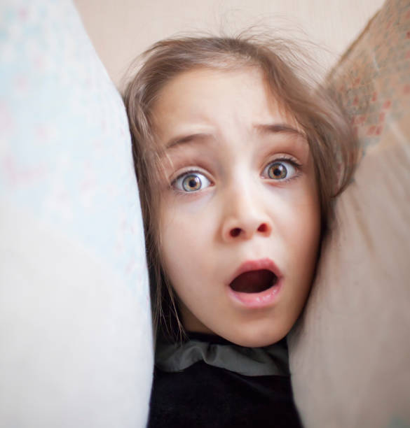 istock Little girl squeezes her head with pillows 1088205900
