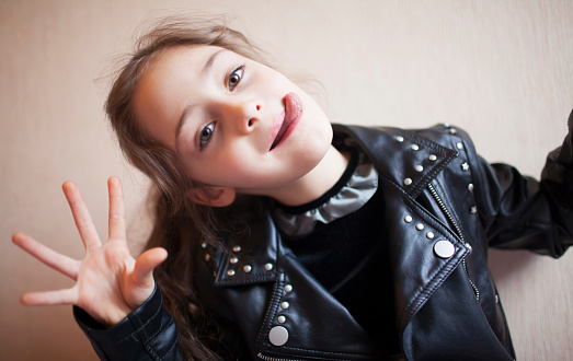 Portrait of a little girl in a rocker jacket isolated