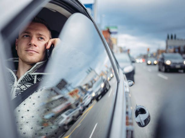 istock Millennial man using phone in a car in winter 1088206314