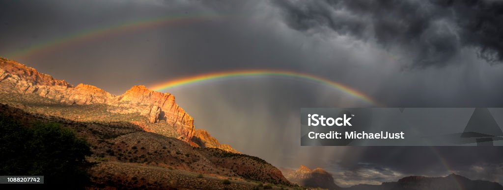 Zion Rainbows A rainbow appears during a monsoonal thunderstorm at Zion National Park, Utah Zion National Park Stock Photo