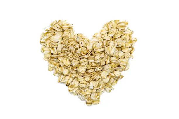 Photo of Oatmeal, heart-shaped, macro, close up, top view. Popular healthy breakfast food. Source of important vitamins, minerals, fiber and antioxidants.