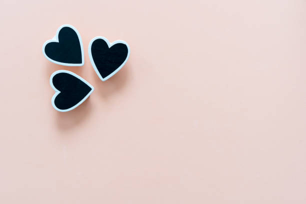 istock Three black hearts on a cream colored background. 1088224440