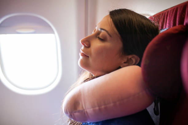 istock Woman sleeping on a plane with travel neck pillow 1088225086