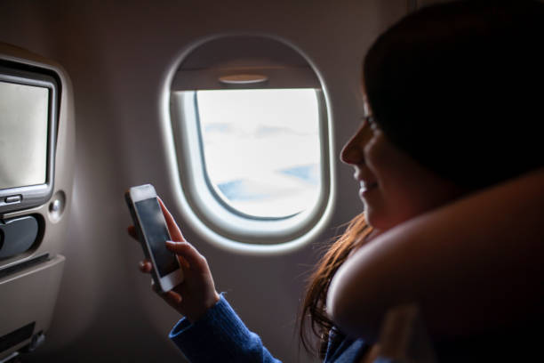 istock Woman using her phone on airplane after landing 1088225156
