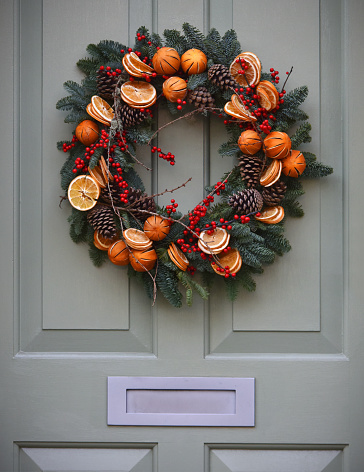 Traditional Decorative Yule Christmas wreath on a Victorian Front with period (19th century) knocker and letter box door in London, UK