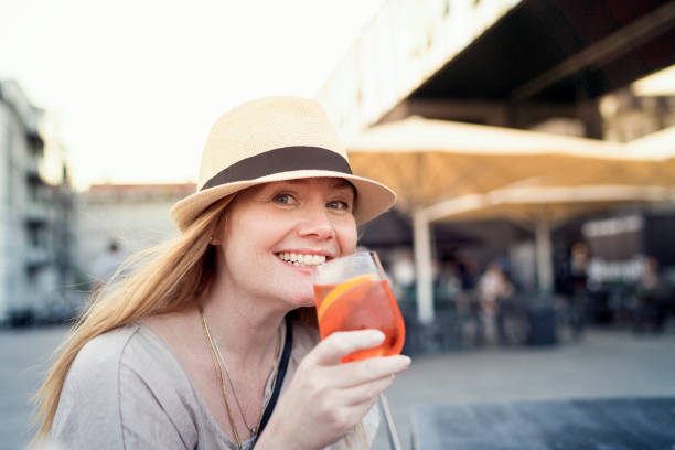 istock Smiling red haired female having happy hour drink outside. 1088230694