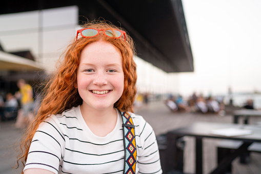 Happy red haired teenage girl smiling and having fun during summer.