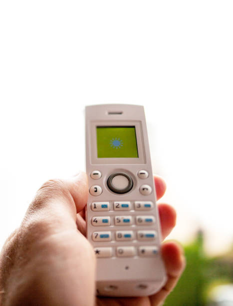 istock Man hand holding cordless phone calling home office 1088234290