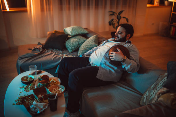 istock Fat man watching basketball match 1088234552