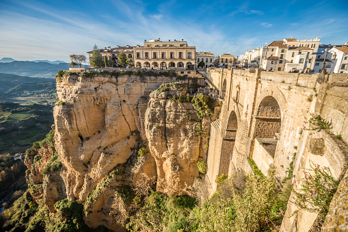 Aerial view of the city of Ronda, with the new bridge in the foreground and the bullring behind. Photo taken early in the morning with the city lights still on. Malaga province, Spain