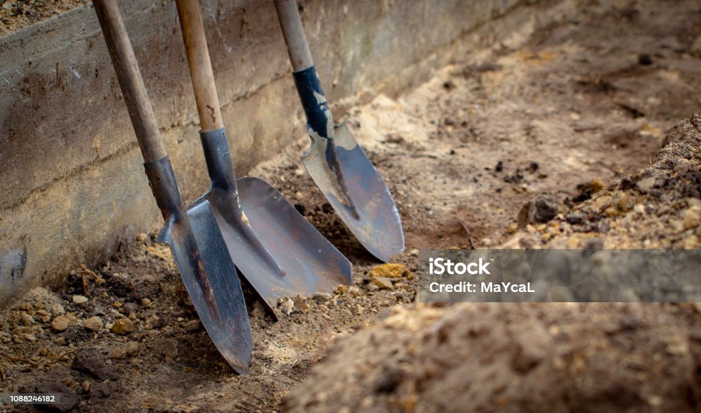 Shovel on a background of the trench Shovel on a background of the trench close up Digging Stock Photo