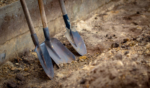 Shovel on a background of the trench Shovel on a background of the trench close up trench stock pictures, royalty-free photos & images