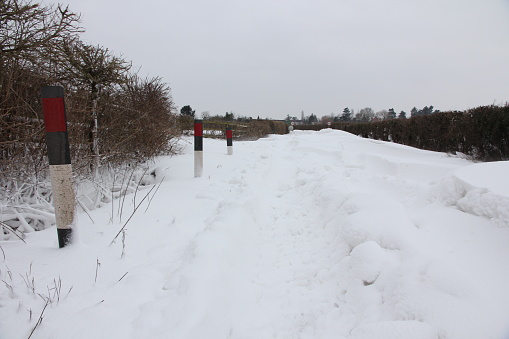 Rural country highway road blocked by deep snowdrifts cut off isolated