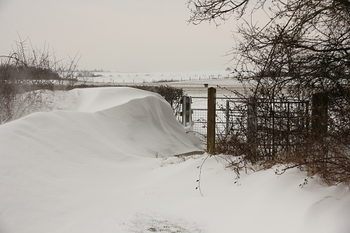 Deep snowdrift sculpted by wind in rural gateway