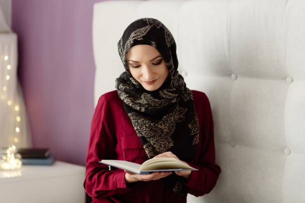 istock Young arabic woman in hijab reading a book 1088254686