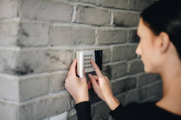 istock Young woman entering security pin on home alarm keypad. 1088256394