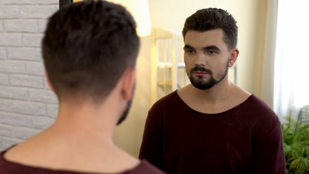 istock Young male bachelor looking in mirror in morning, appearance insecurities 1088258376