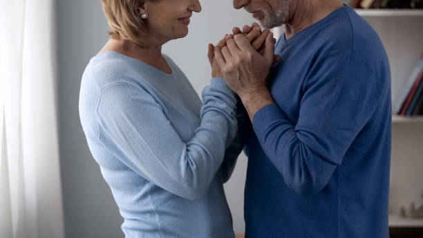 istock Retiree couple holding hands, looking at each other with love and gratefulness 1088258428