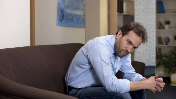 istock Pensive male sitting on couch alone at home, losing job, unemployment problem 1088258538