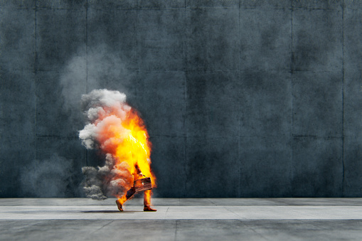 Businessman in flames walking on the street. This is entirely 3D generated image.