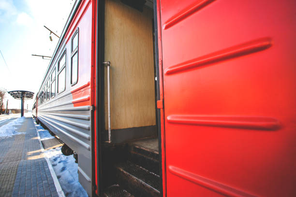 The red train is standing near the platform with the doors open, retro toned