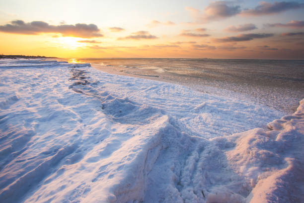 istock a beach under snow and a cold, ice-covered sea during sunset 1088265812