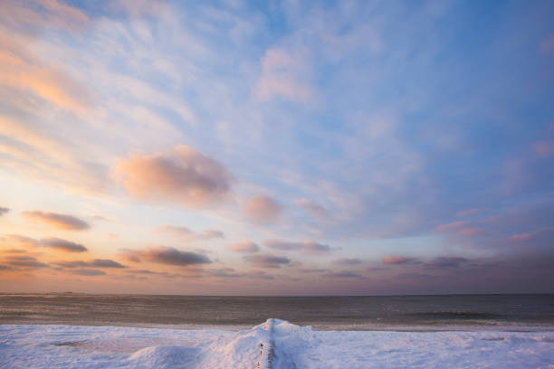 istock snow-covered breakwaters on a winter beach near a cold, ice-covered sea during sunset 1088265834