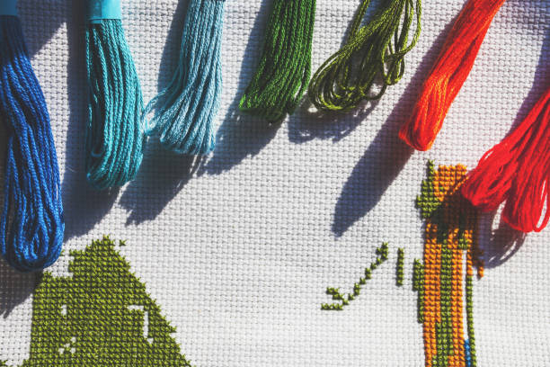 istock multicolored threads and cross stitch, retro toned 1088265904