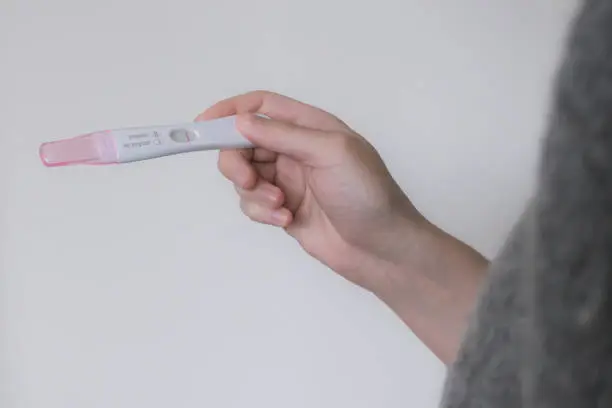 A woman holding a negative pregnancy test