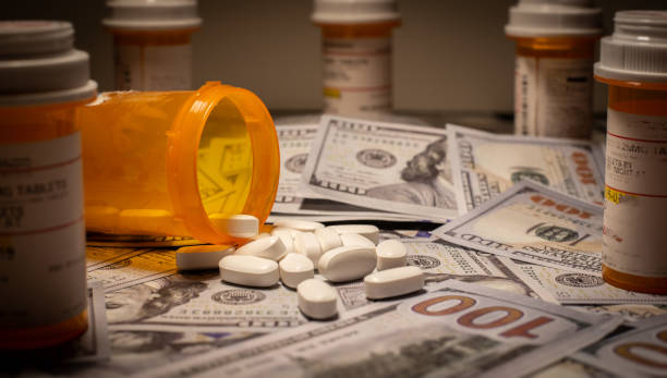 Opioids and US Currency Prescription medication is strewn out upon US currency. fentanyl stock pictures, royalty-free photos & images