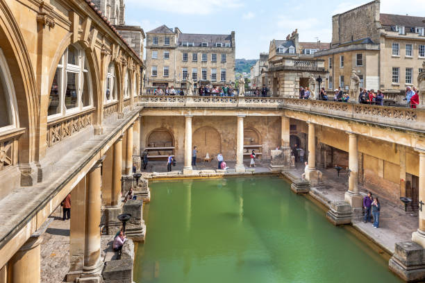 Bath, England - August 5, 2014: A view of the Roman Baths in Bath, Somerset, England, showing the hot springs and tourists going about their busines
