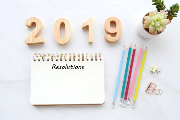 istock 2019 resolution on blank notebook paper on white table background, 2019 new year mock up, template, flat lay 1088337790