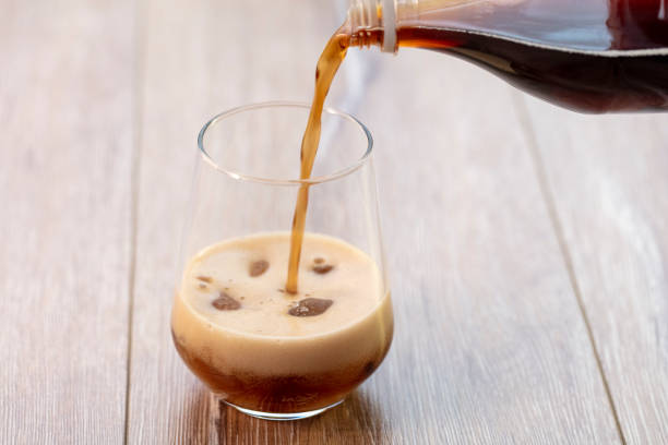 istock Soda (cola) being poured into plain glass with ice 1088349530
