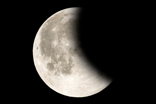 Earth's permanent natural satellite - the Moon during a Lunar eclipse - penumbra. A lunar eclipse occurs when the Moon passes directly behind the Earth. High resolution 6 mp image. On a black background.