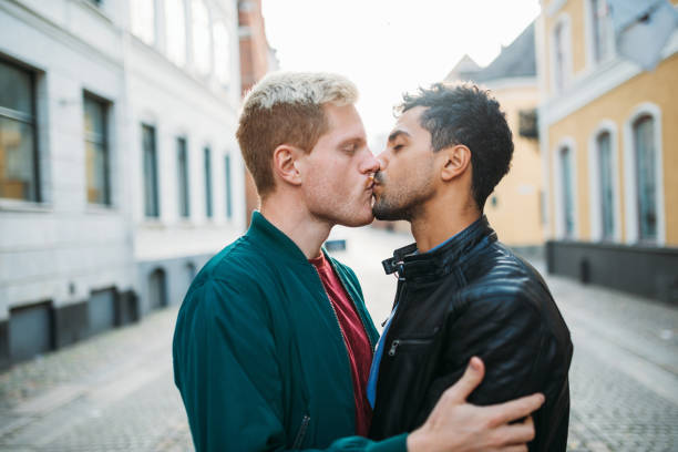 pareja gay en la ciudad de rompe en romántica luna de miel - hombres gay latinos y escandinavos disfrutando de su vida en común juntos - gay man homosexual men kissing fotografías e imágenes de stock