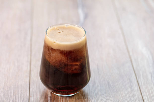 istock Soda (cola) being poured into plain glass with ice 1088361160