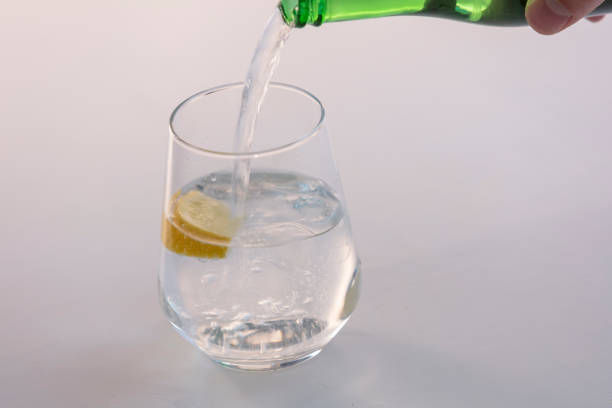 istock Soda or Water being poured into plain glass with ice 1088361238