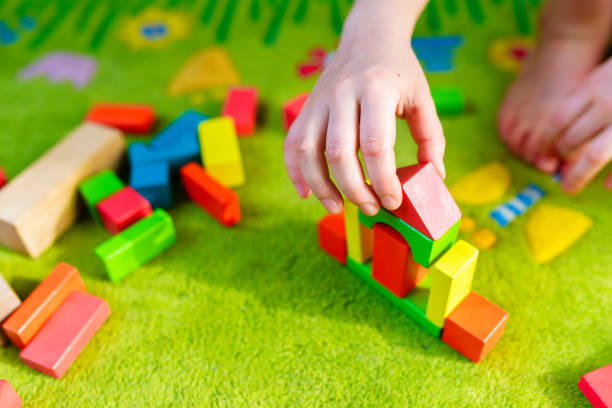 istock Small child playing with wooden blocks on green carpet 1088374430
