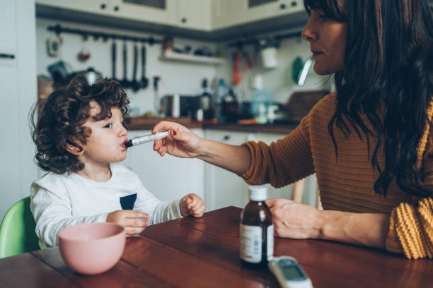 istock Mother giving syrup to her son 1088379538