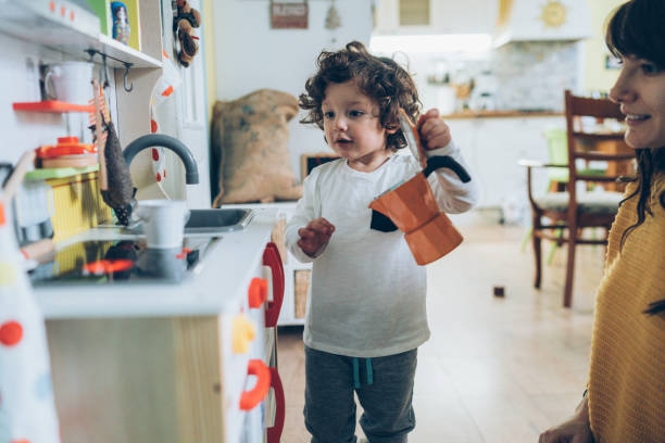 Mon and boy playing in toy kitchen