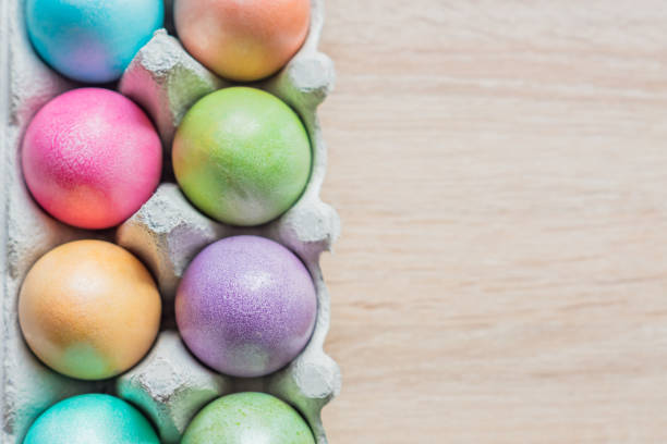 istock Multicolored easter eggs in a box. Top view on wooden background. Copy space for your text 1088382782