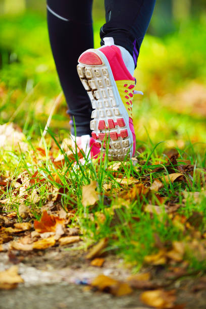 istock Woman jogging away from camera wearing trainers 1088389080