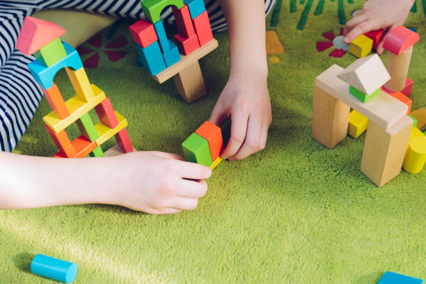istock Small child playing with wooden blocks on green carpet 1088389328